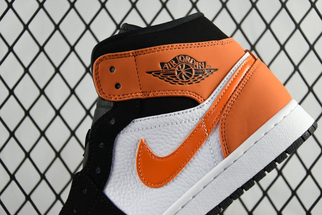 Air Jordan 1 Mid sneakers with orange ankle panel and black laces, side swoosh visible