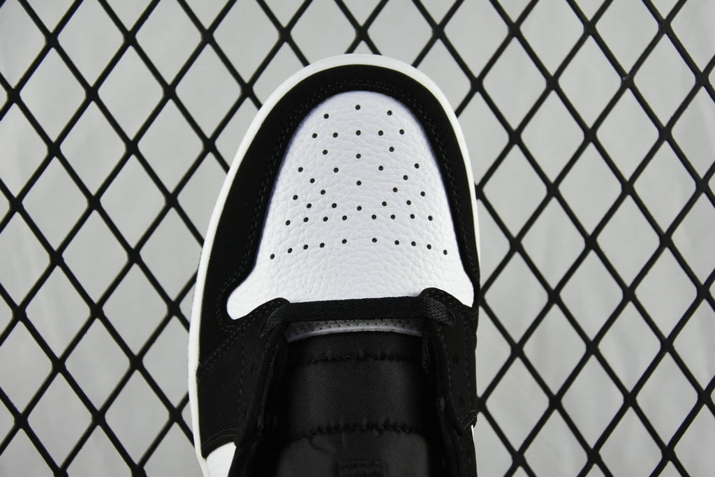 Air Jordan 1 Mid sneaker toe view with black upper, white perforated toe box