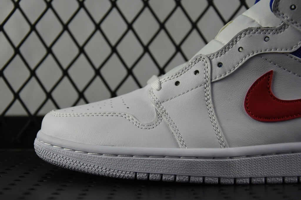 White leather sneaker with red swoosh and blue trim stitching near toe.