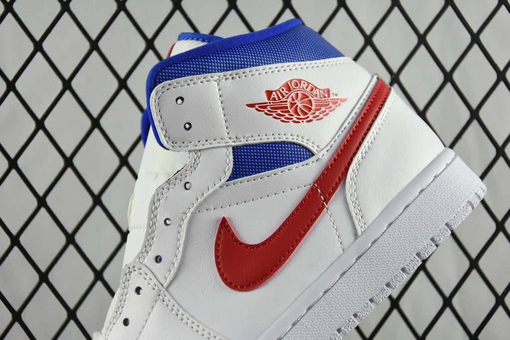 White mid-top sneaker with blue ankle panel, red swoosh, and logo patch.