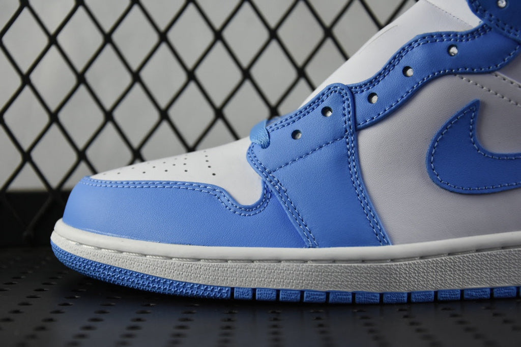 Side view of mid-top basketball shoe with blue swoosh and lace eyelets