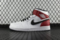 Mid-top sneaker with white leather upper and red ankle panel, black swoosh