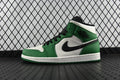 Air Jordan 1 Mid green and white high-top sneaker with black swoosh