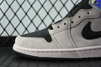 Air Jordan 1 Mid sneaker close-up, light gray suede with black swoosh and perforated toe