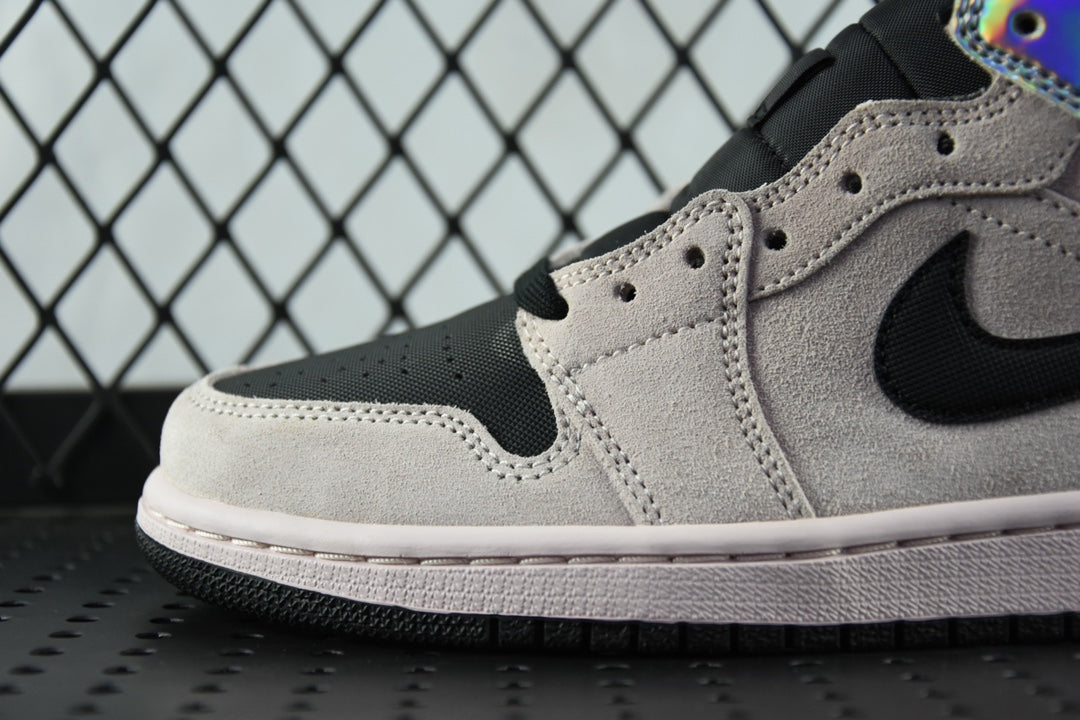 Air Jordan 1 Mid sneaker close-up, light gray suede with black swoosh and perforated toe