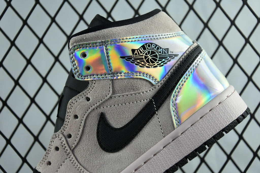 Air Jordan 1 Mid sneaker close-up, iridescent lace strap with black swoosh on gray suede