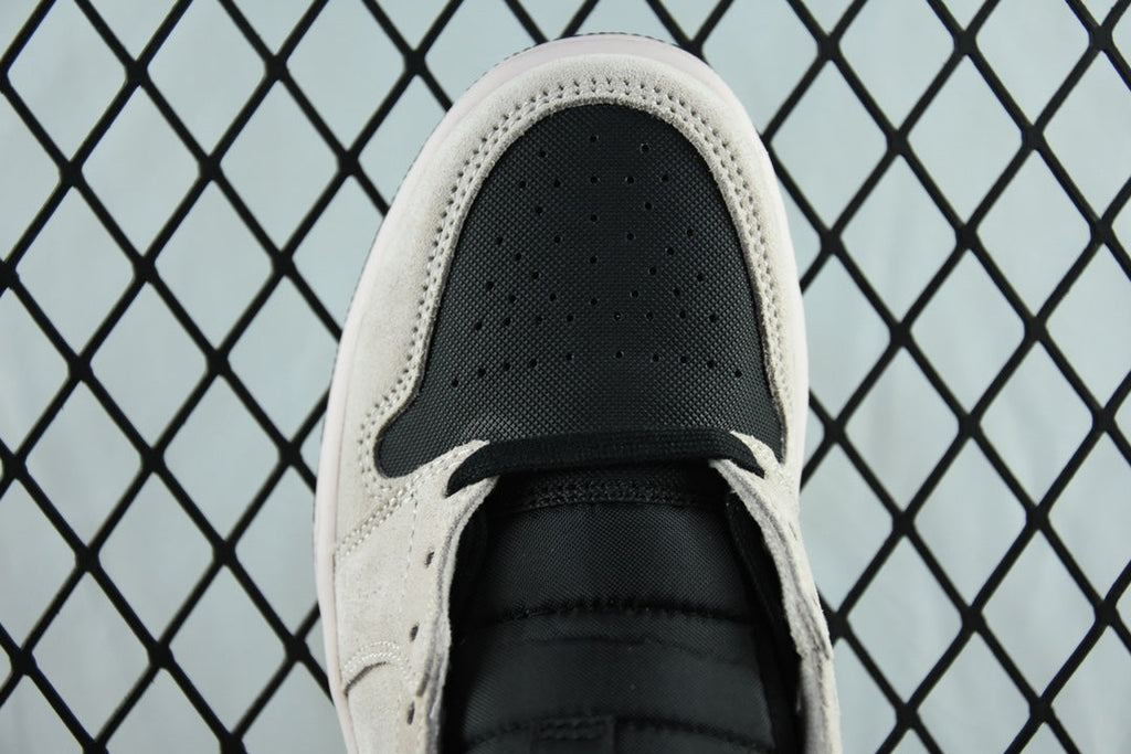 Air Jordan 1 Mid sneaker toe view, perforated light gray upper with black swoosh