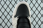 Air Jordan 1 Mid sneaker toe view, perforated light gray upper with black swoosh