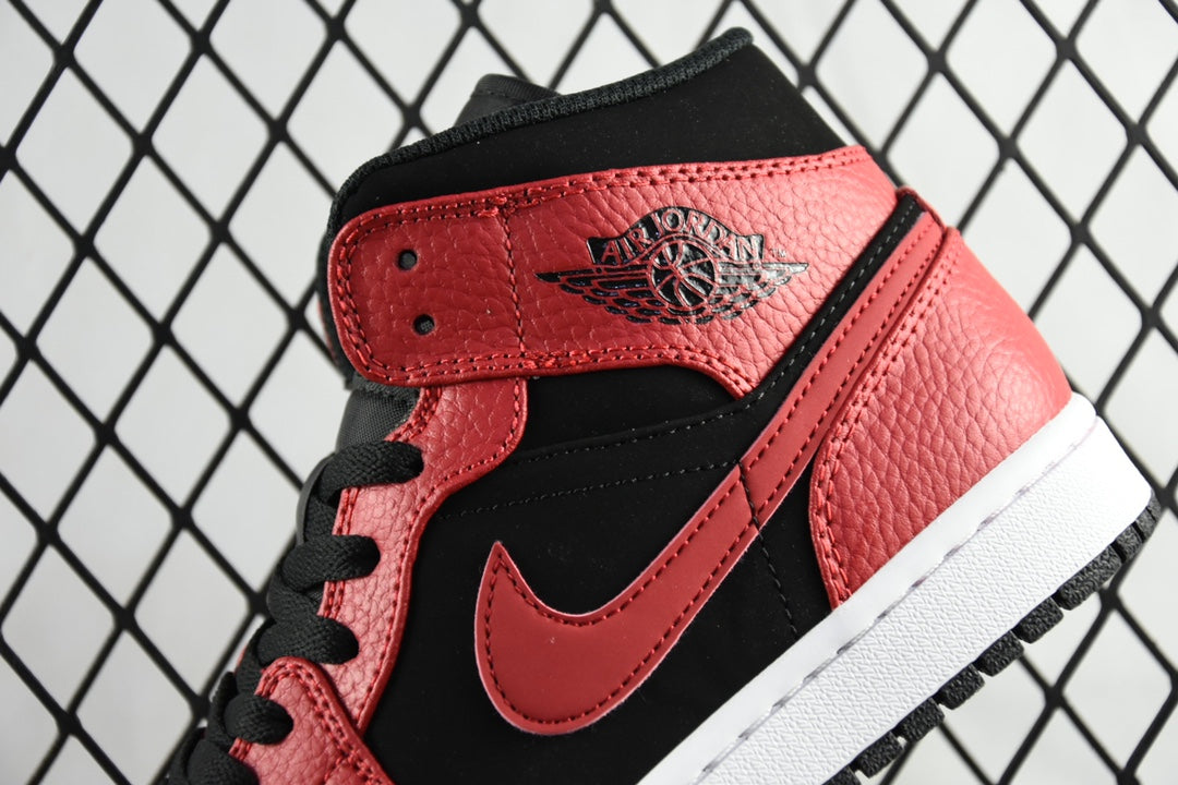 Red and black mid-top sneaker with logo tongue patch and black lace-up closure
