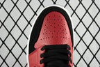 Close-up of red perforated toe box on black and red mid-top sneaker