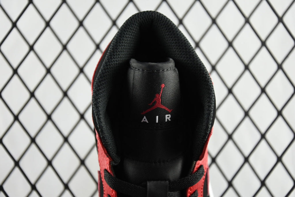 Inside heel view of black insole with red Jumpman logo on mid-top sneaker