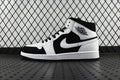 Black and white mid-top sneakers with lace-up, Nike Swoosh on side, Air Jordan logo