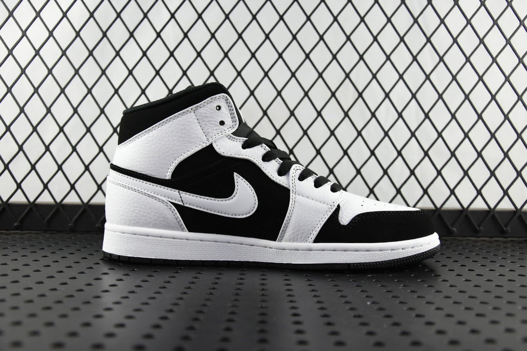 Black and white mid-top sneakers with large Swoosh logo and padded collar