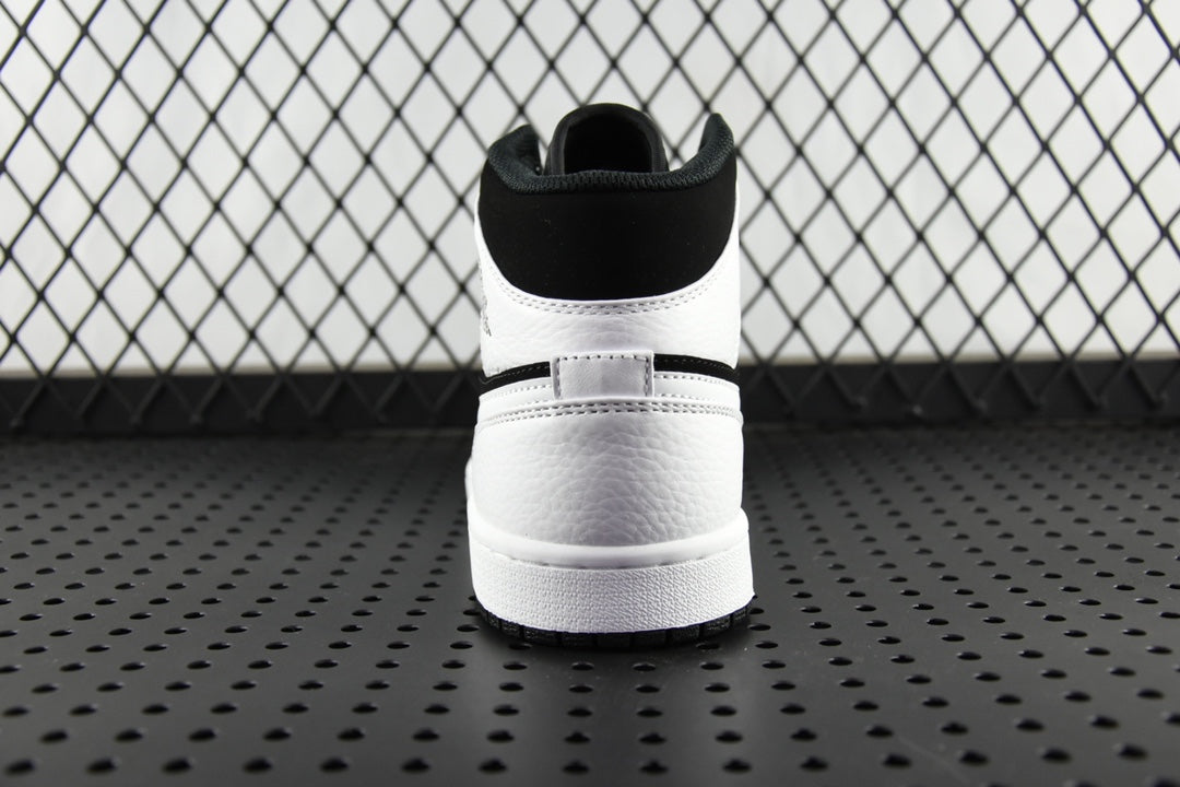 Black and white mid-top sneakers, rear collar and rubber heel sole