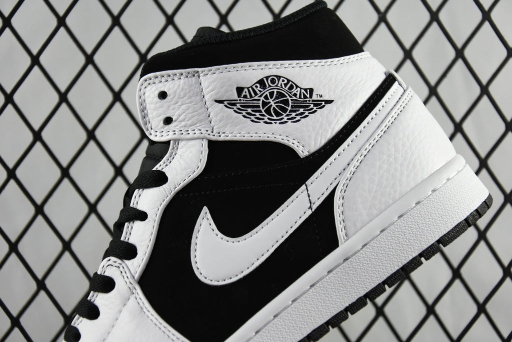 Black and white mid-top sneakers with Air Jordan wings logo on tongue