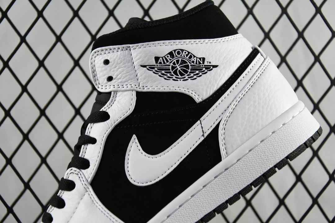 Black and white mid-top sneakers with Air Jordan wings logo on tongue