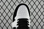 Black and white mid-top sneakers, perforated white toe cap and black laces