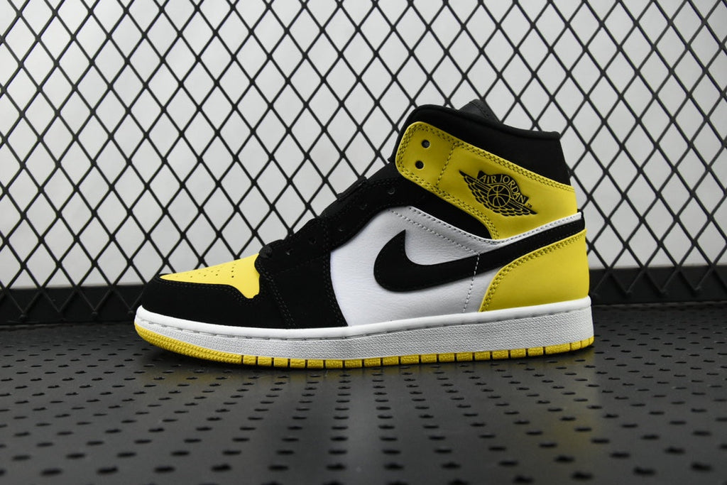 Air Jordan mid-top sneaker in black, white, and yellow with large swoosh
