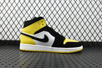 Air Jordan mid-top sneaker side view with yellow ankle panel and black overlays