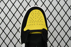 Air Jordan sneaker close-up of black-and-yellow perforated toe cap