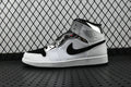 Air Jordan 1 Mid sneakers in white and black, high-top side view with swoosh
