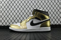 Mid-top sneaker with metallic gold and white panels, black Nike swoosh, black collar