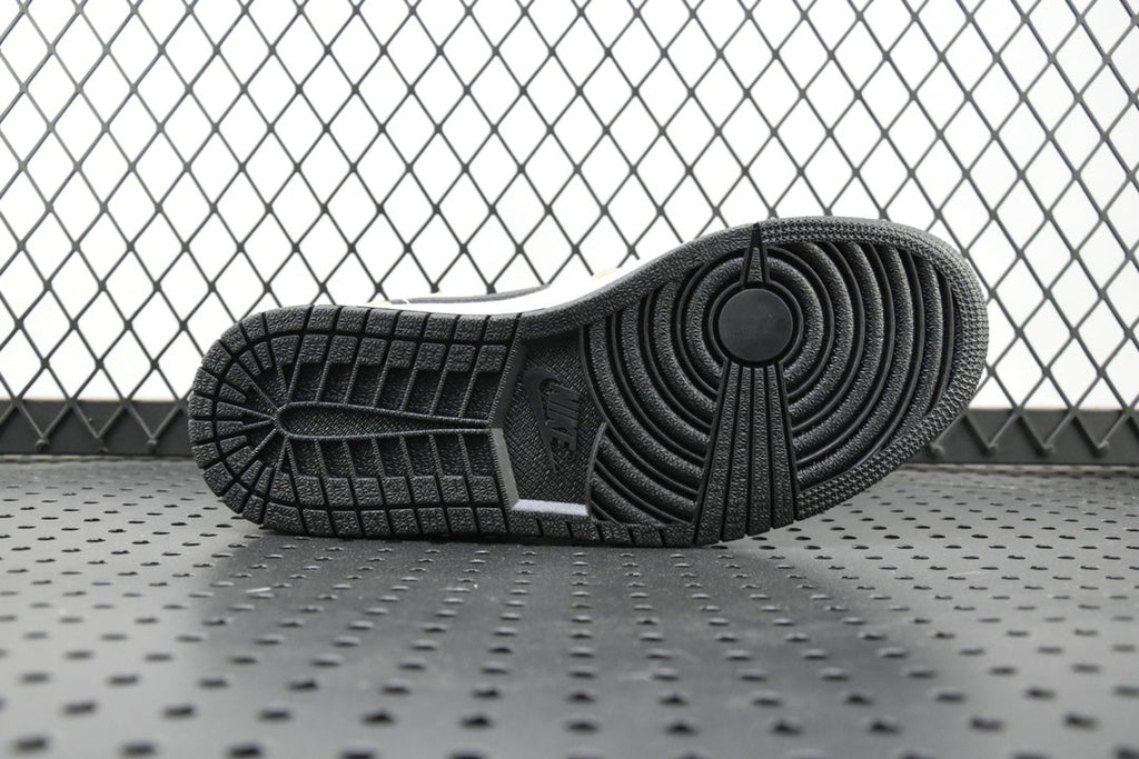 Black rubber outsole with tread pattern on a mid-top sneaker