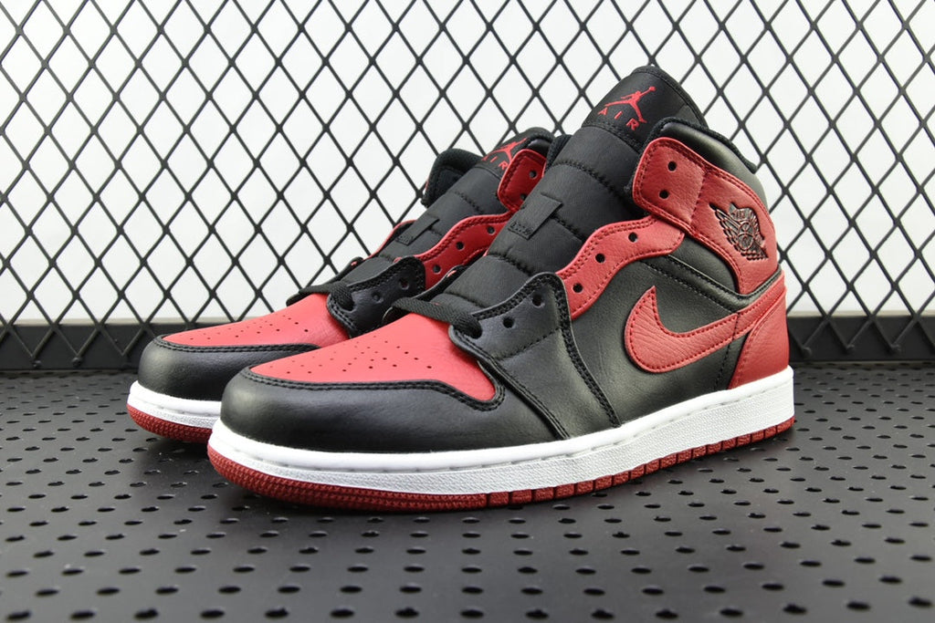 Mid-top sneaker with red panels, black overlays, and white outsole