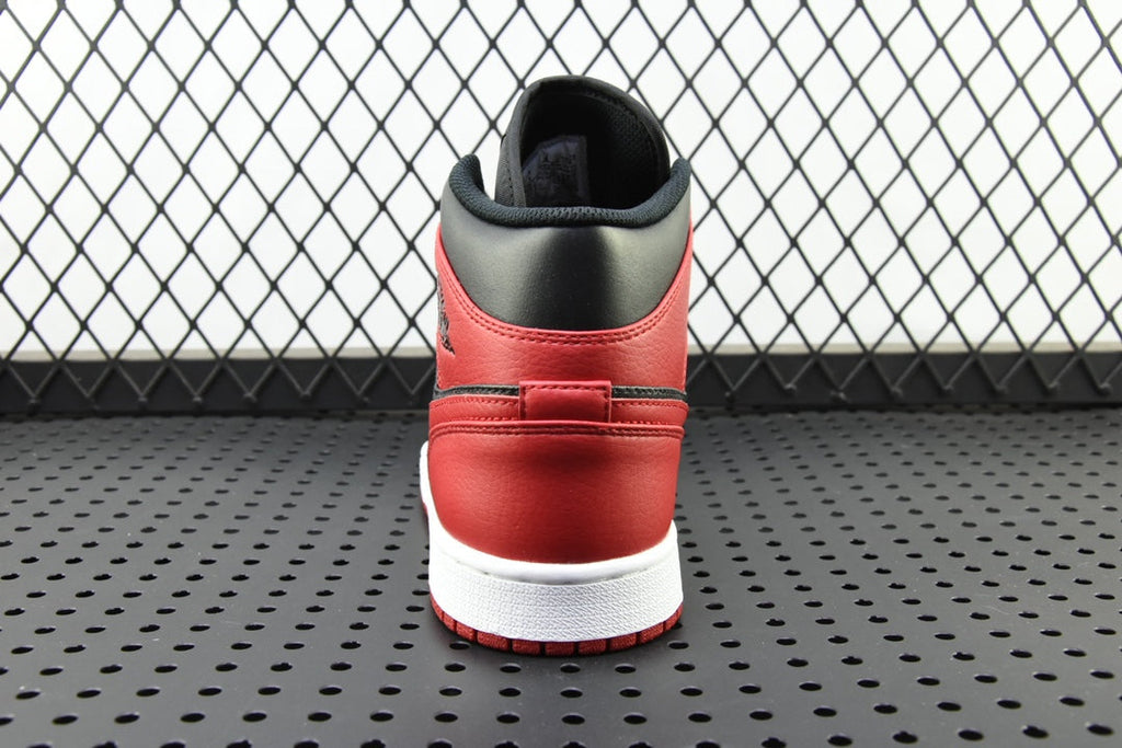 Back view of mid-top sneaker with red heel, black collar, and white sole