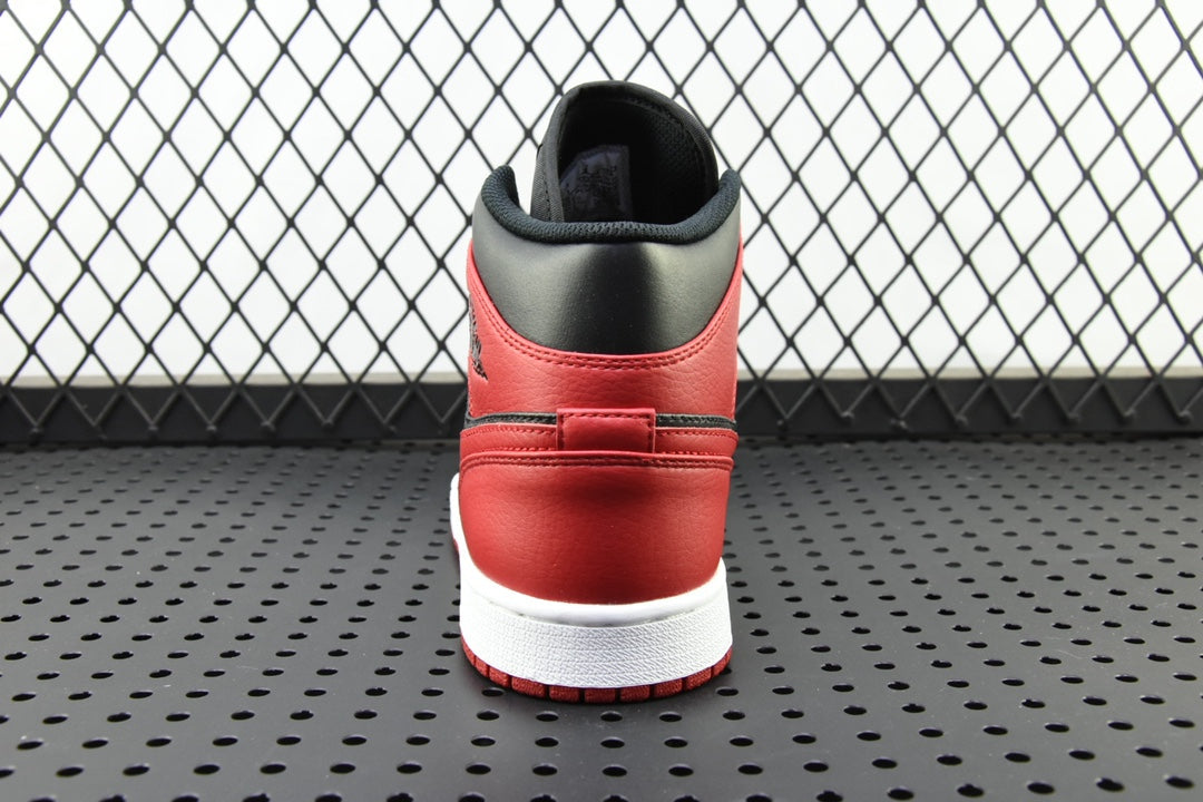 Back view of mid-top sneaker with red heel, black collar, and white sole