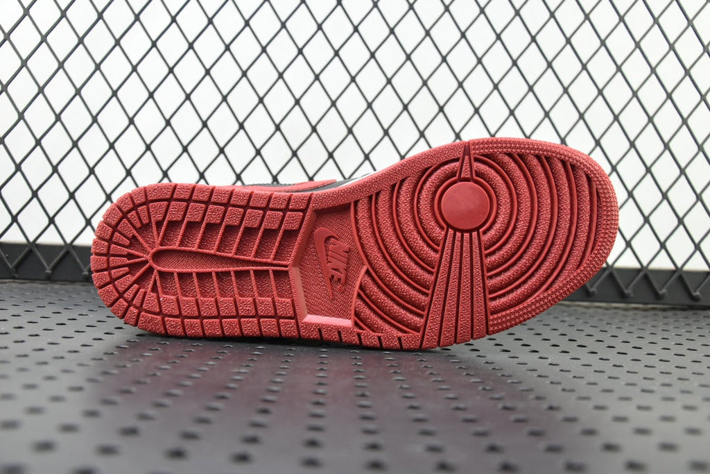 Red rubber outsole tread of a mid-top sneaker with circular pattern