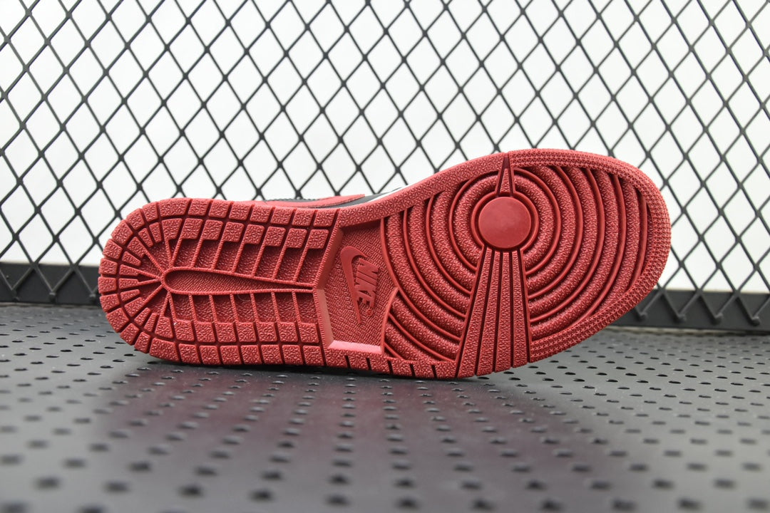 Red rubber outsole tread of a mid-top sneaker with circular pattern