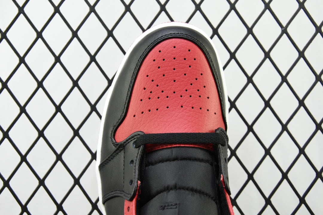 Toe cap of mid-top sneaker with red perforated leather and black laces