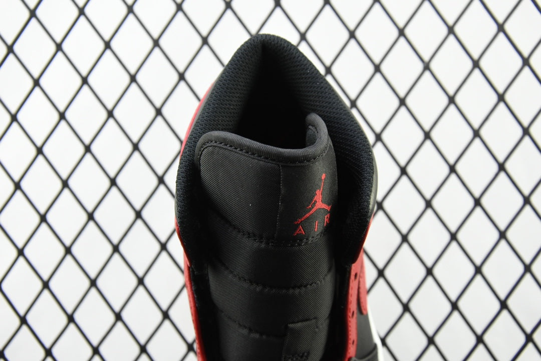 Heel view of mid-top sneaker with black leather upper and red accents