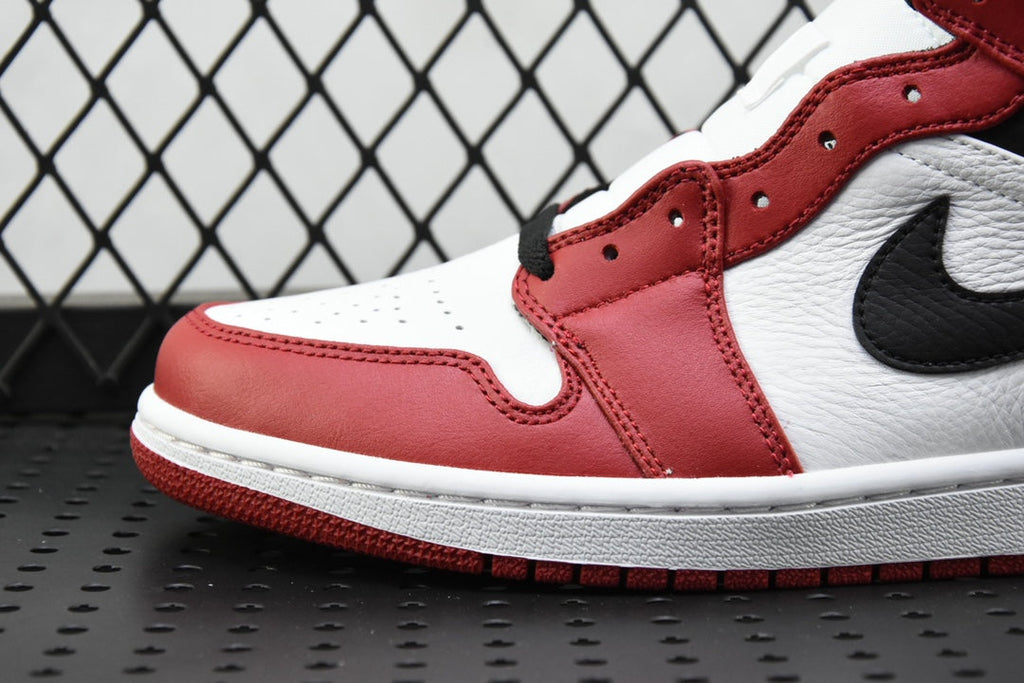 Close-up of mid-top sneaker toe and side panel in red, white, and black