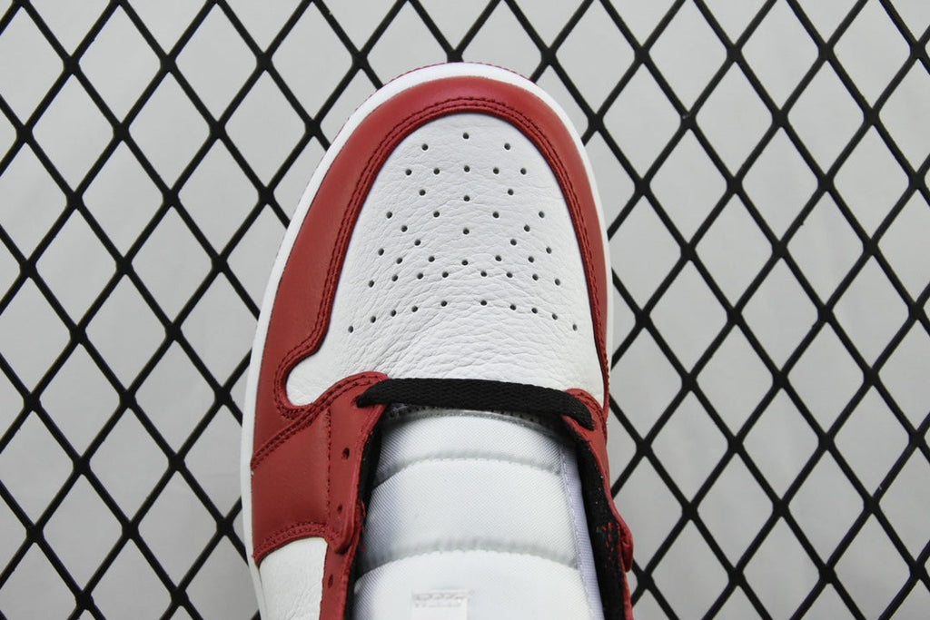 Mid-top sneaker toe cap view with perforations and red trim