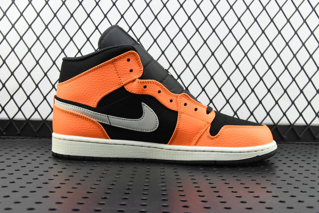 Mid-top sneakers side view in orange and black with a white swoosh and white midsole