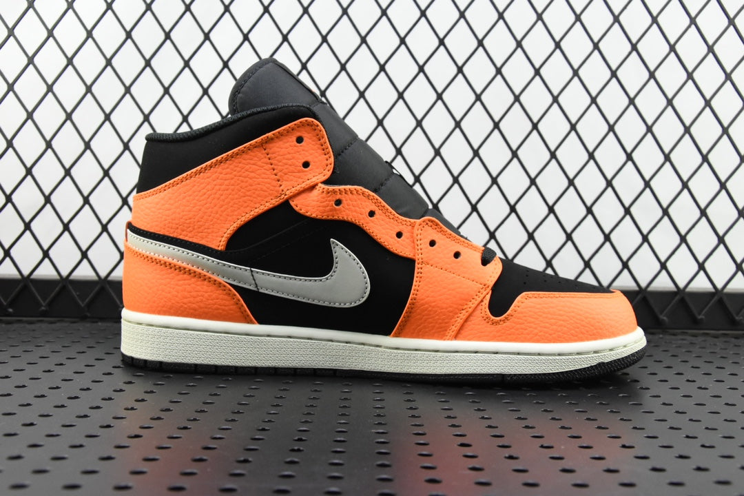 Mid-top sneakers side view in orange and black with a white swoosh and white midsole