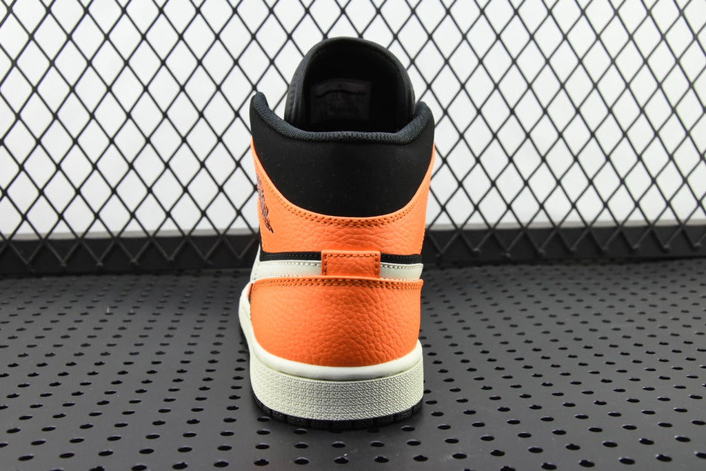 Back view of mid-top sneakers with orange heel panel, black collar, and white sole
