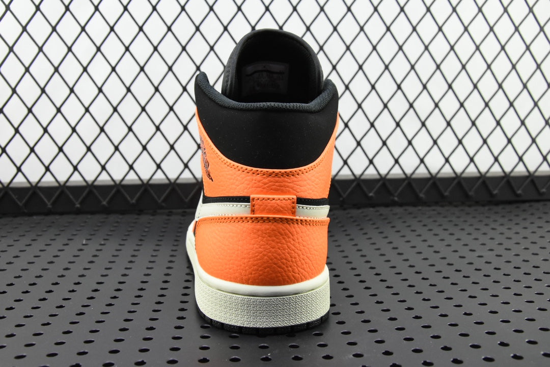 Back view of mid-top sneakers with orange heel panel, black collar, and white sole