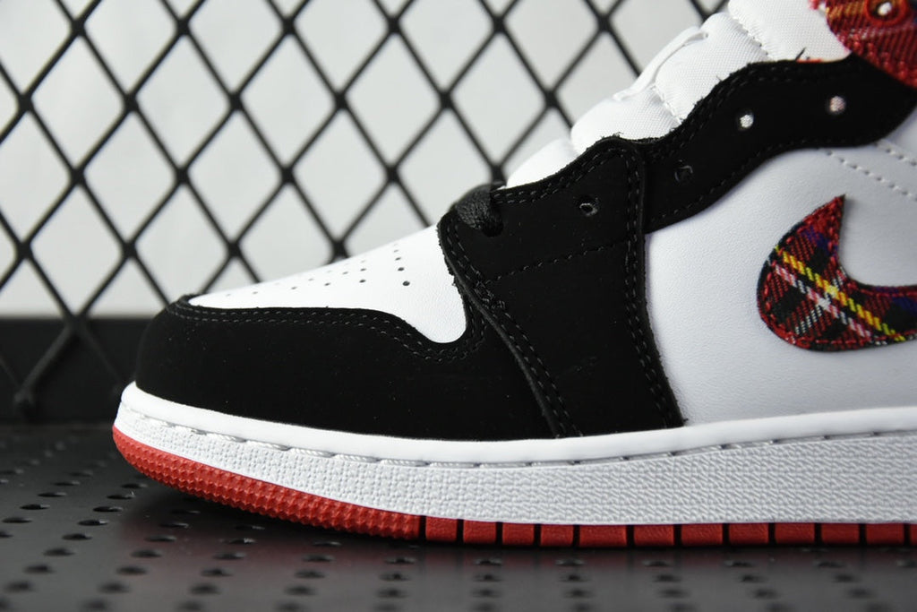 Black and white mid-top sneakers with stitched swoosh and red plaid collar detail
