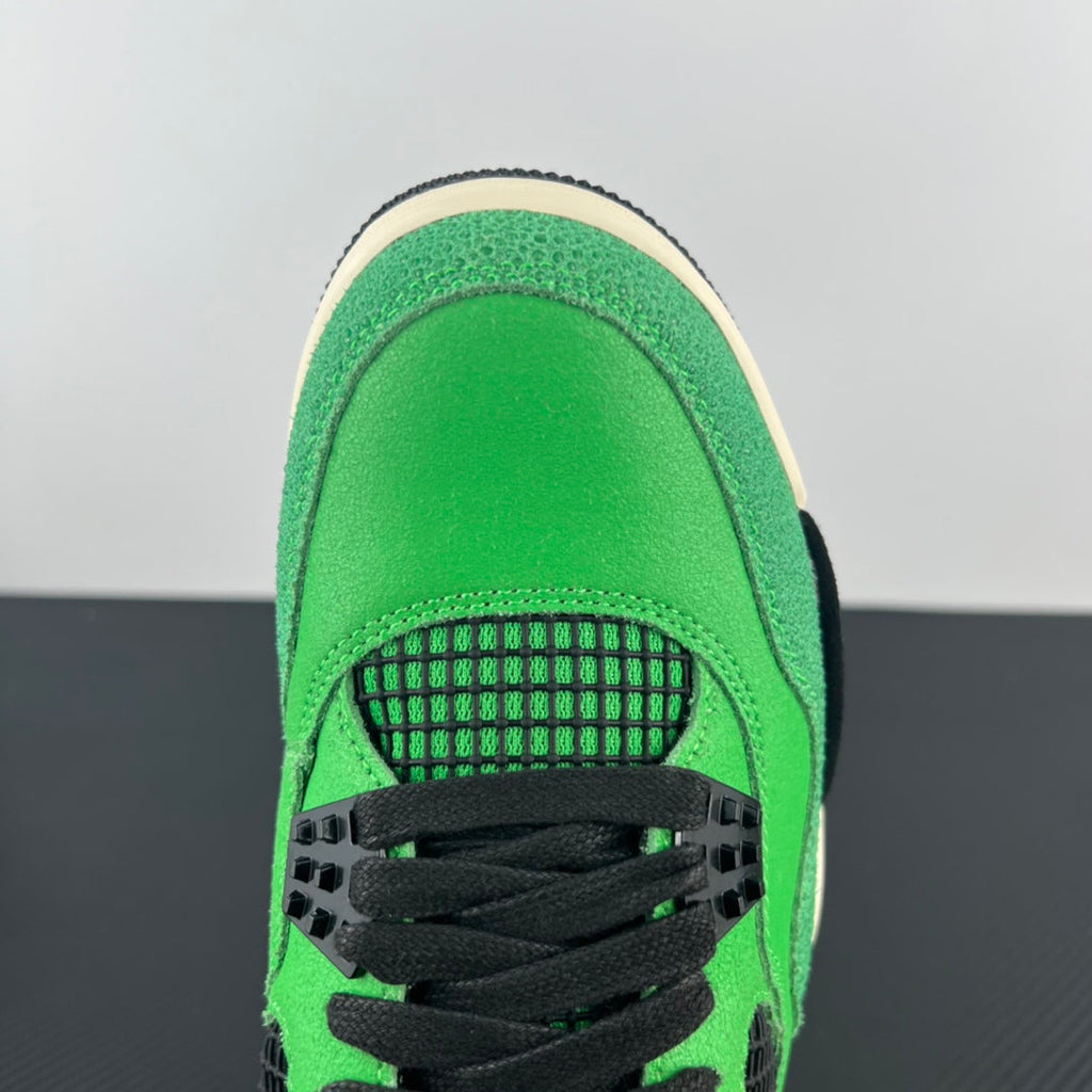 Air Jordan 4 sneaker rear view with black laces and green heel overlay