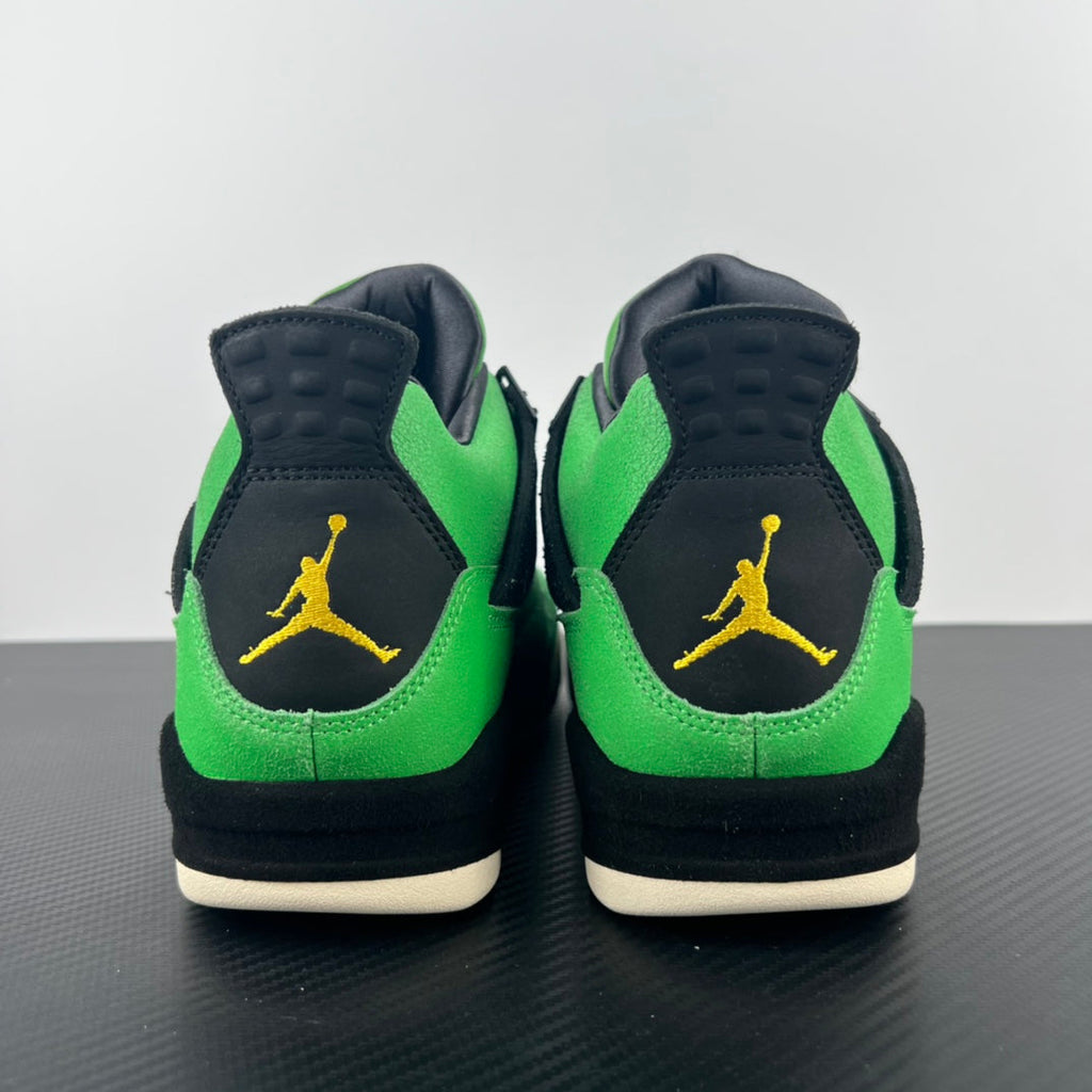 Pair of Air Jordan 4 sneakers from heel showing black back panels and green uppers