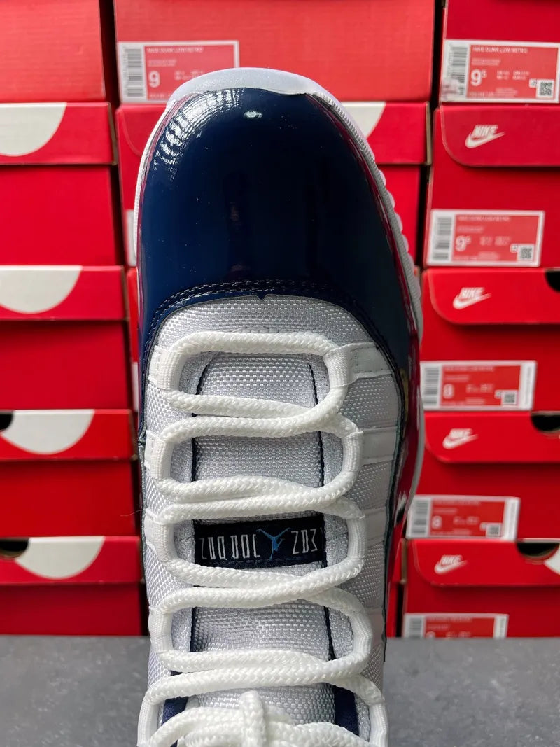 Air Jordan 11 sneakers close-up of toe and laces, navy-and-white upper