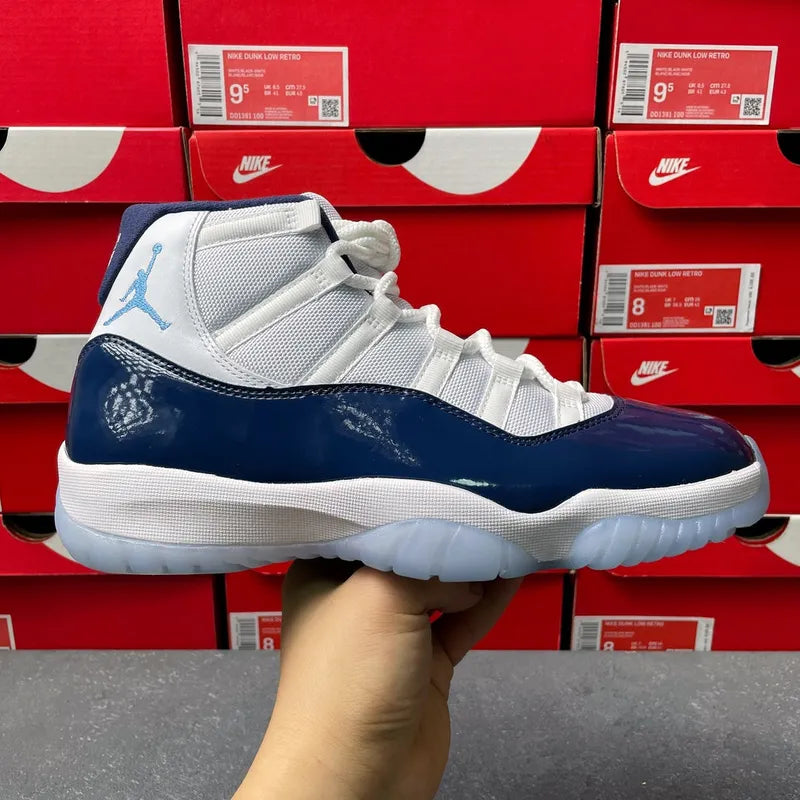 Air Jordan 11 sneakers top view with white tongue, lace-up front, and navy accents