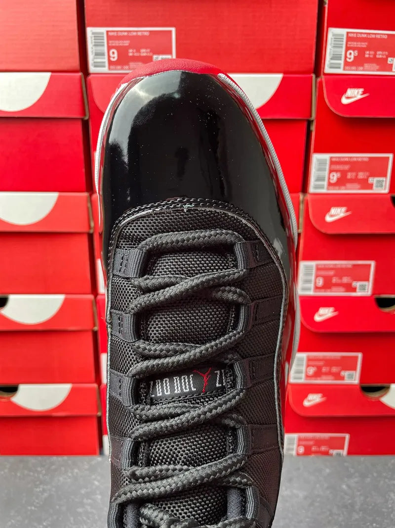 Black high-top sneaker toe and lace area with textured panels and gray stitching