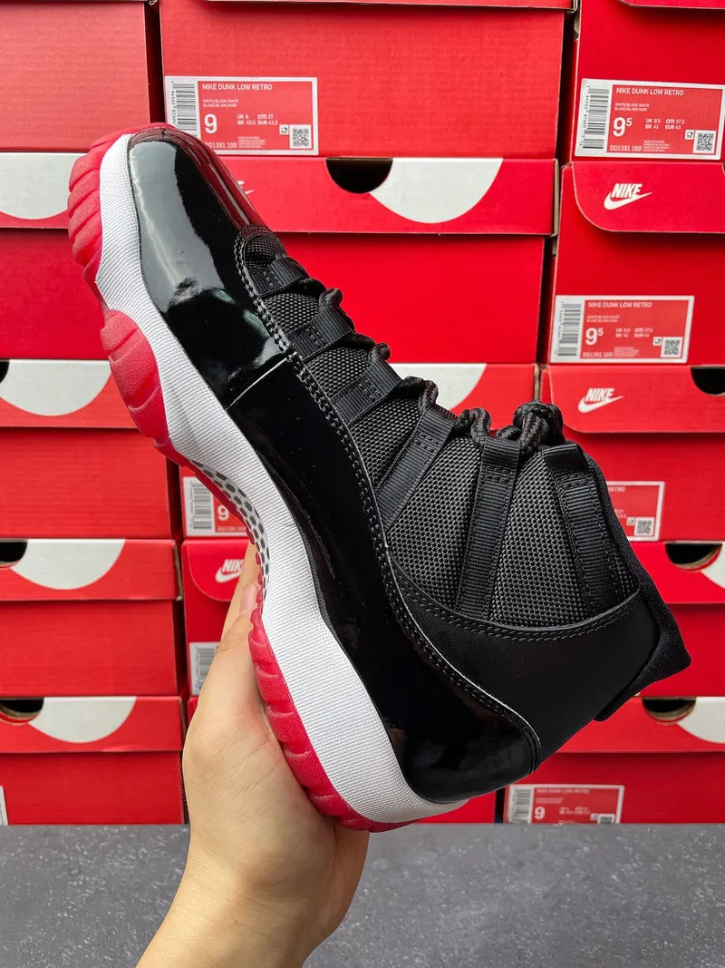 Black high-top sneaker with white midsole and red outsole edge, side view