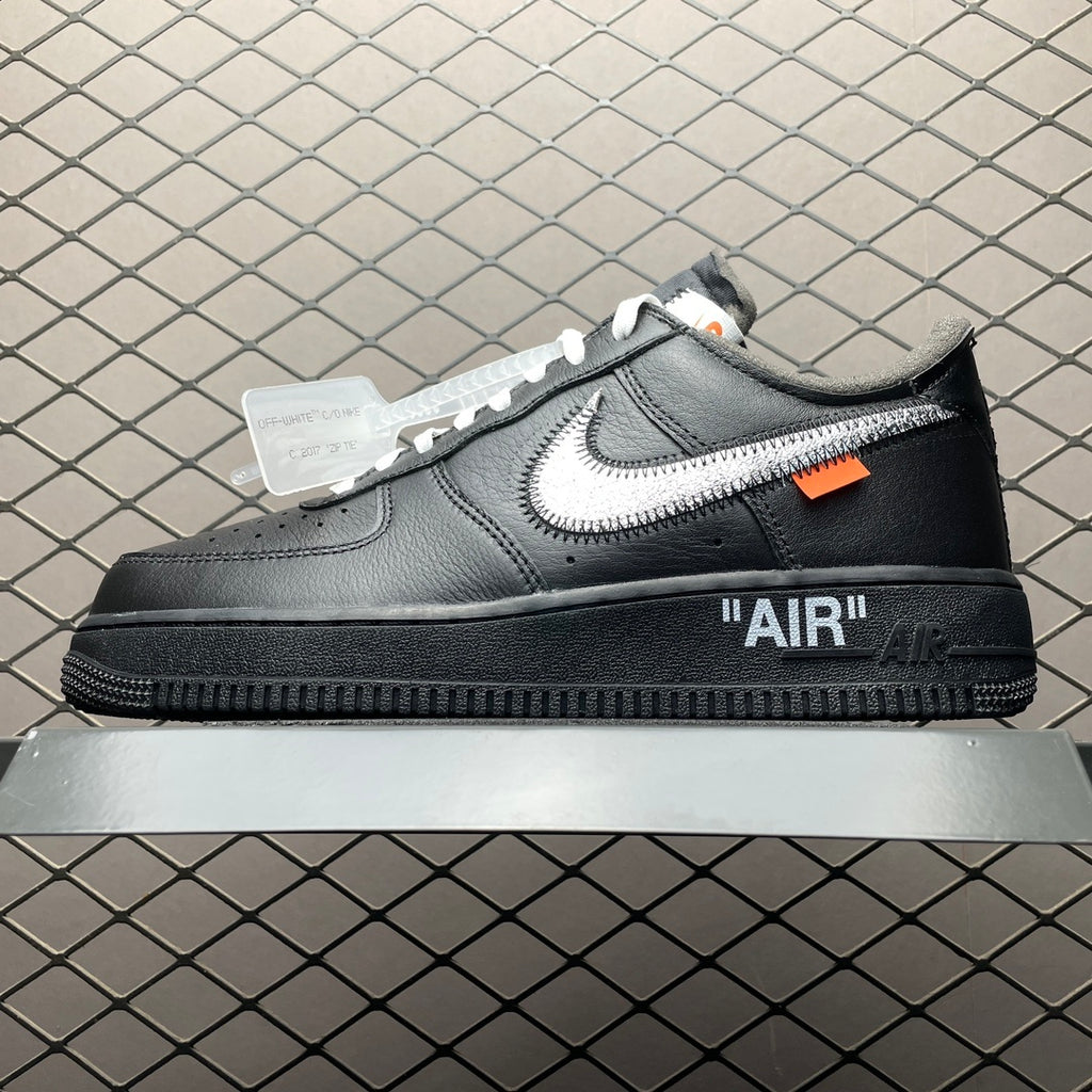 Black low-top Air sneaker with white swoosh, orange tag, and "AIR" heel logo