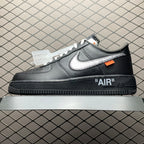 Black low-top Air sneaker with white swoosh, orange tag, and "AIR" heel logo