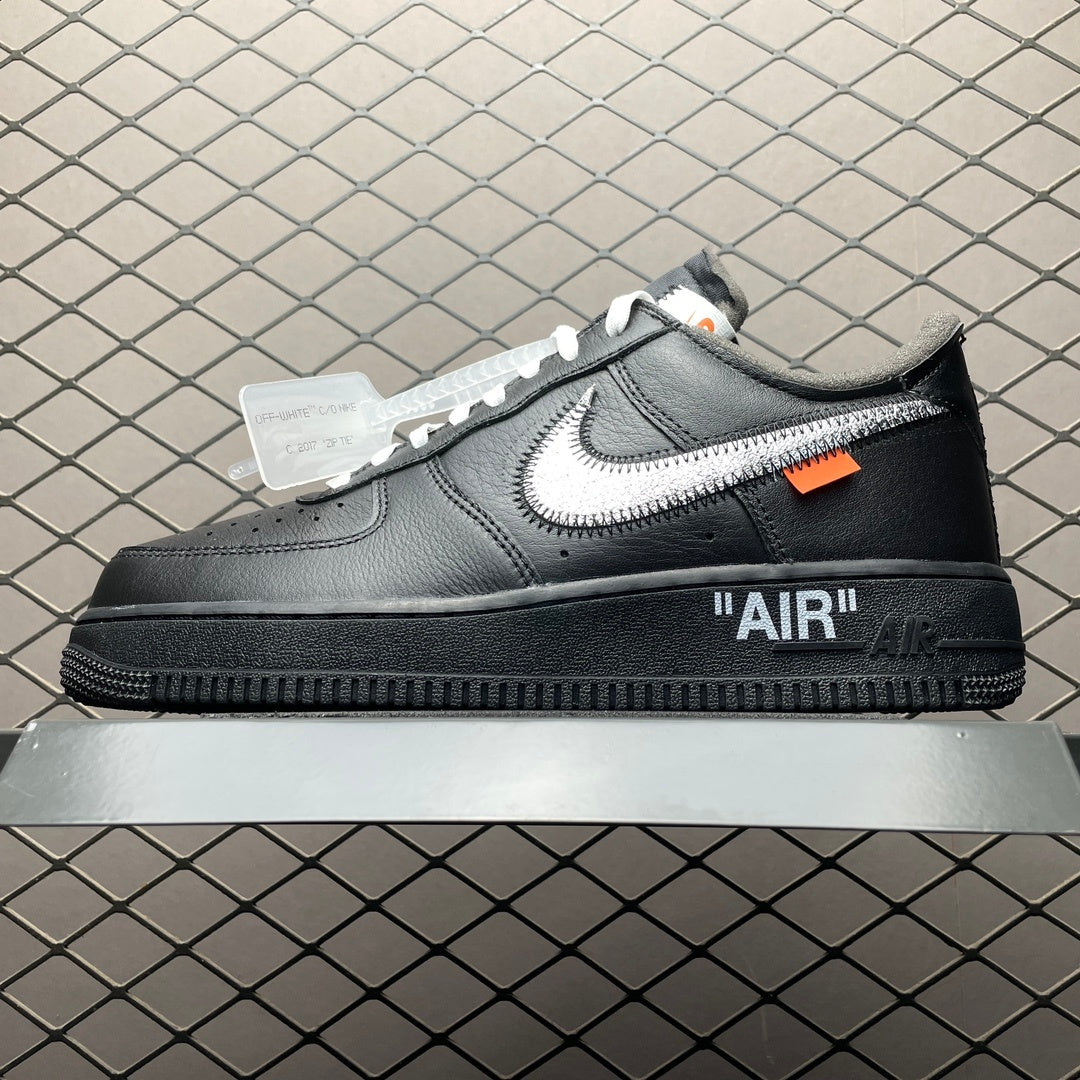 Black low-top Air sneaker with white swoosh, orange tag, and "AIR" heel logo